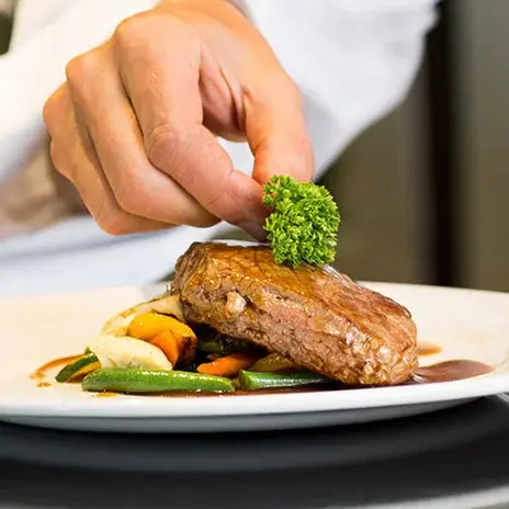Glenmoore Chef Created Meals, chef garnishing a plate.