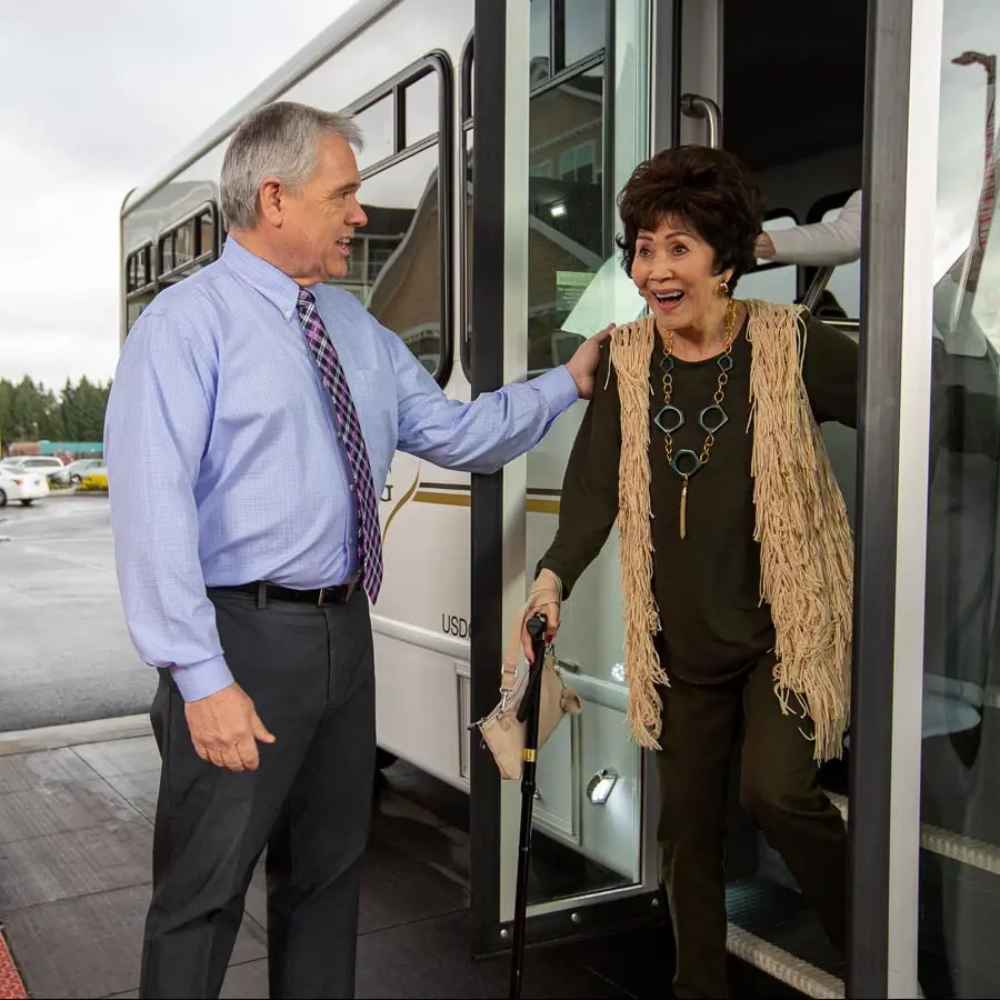 [[community_name]] man helping lady off bus