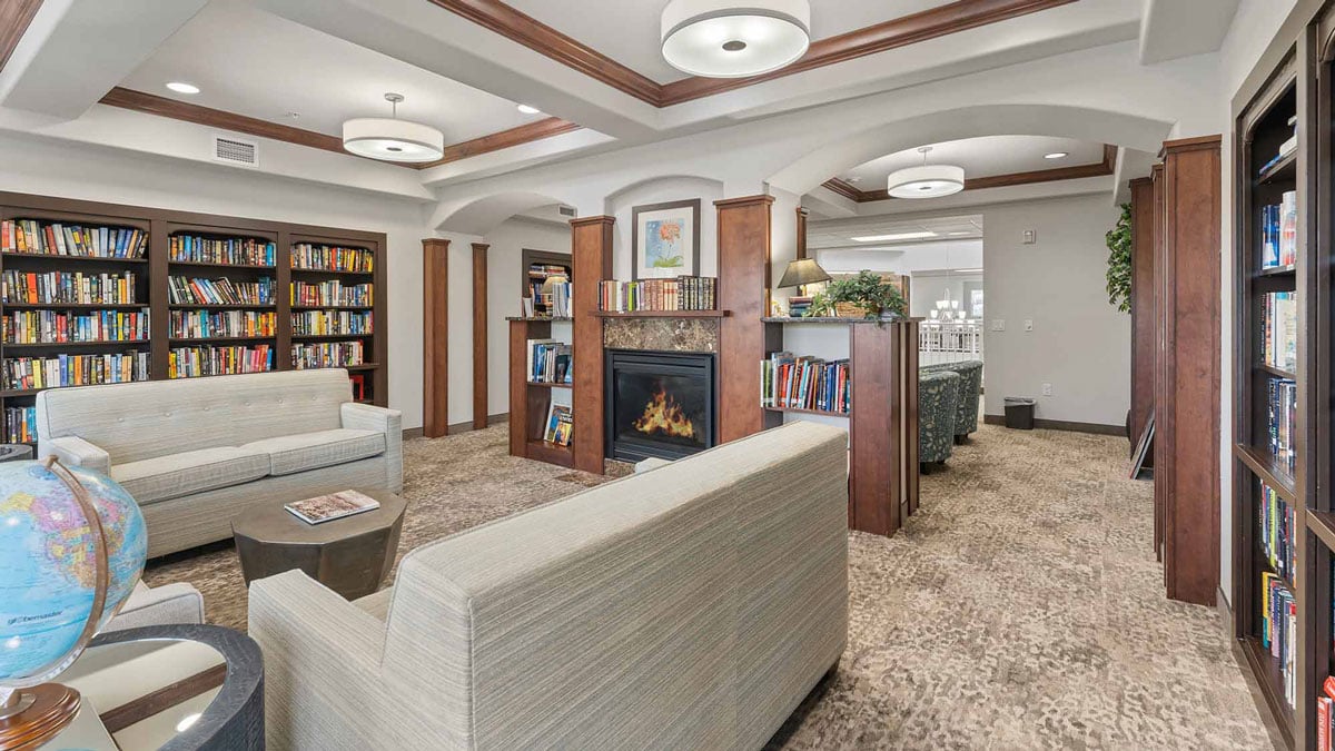 The library at Glenmoore with shelves of books and comfortable seating